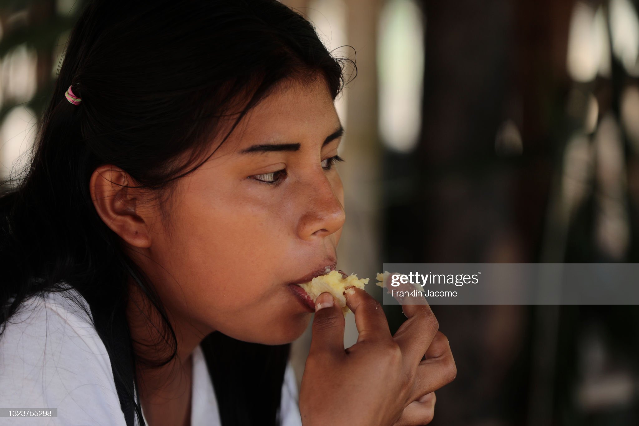 rosa-gualinga-chews-yucca-to-prepare-the-traditional-chewed-chicha-picture-id1323755298