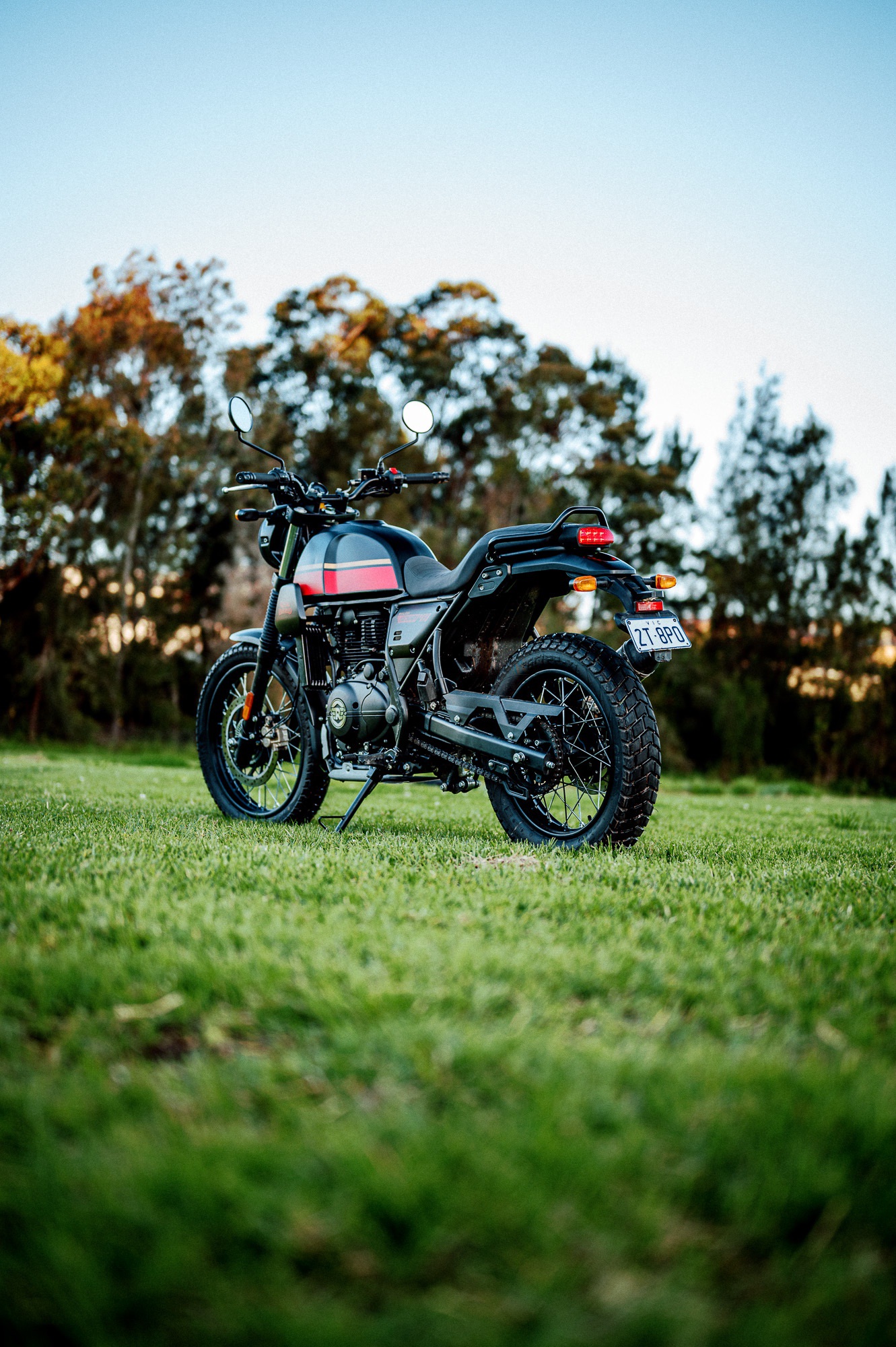 A 2022 Royal Enfield Scram 411 motorcycle in a park at dusk