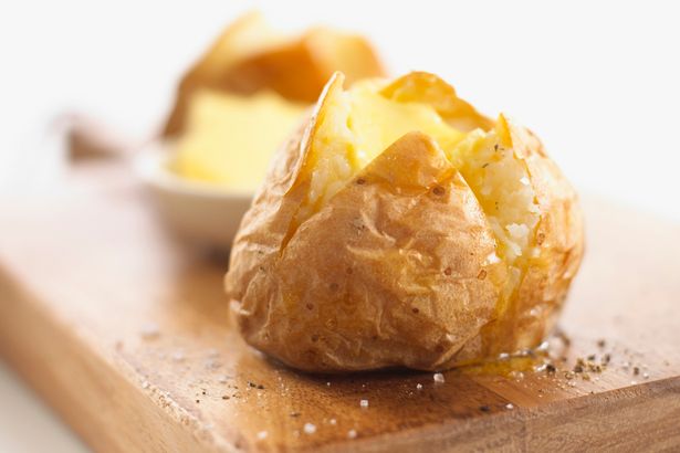 A-jacket-potato-with-butter-salt-and-pepper-on-a-wooden-chopping-board.jpg