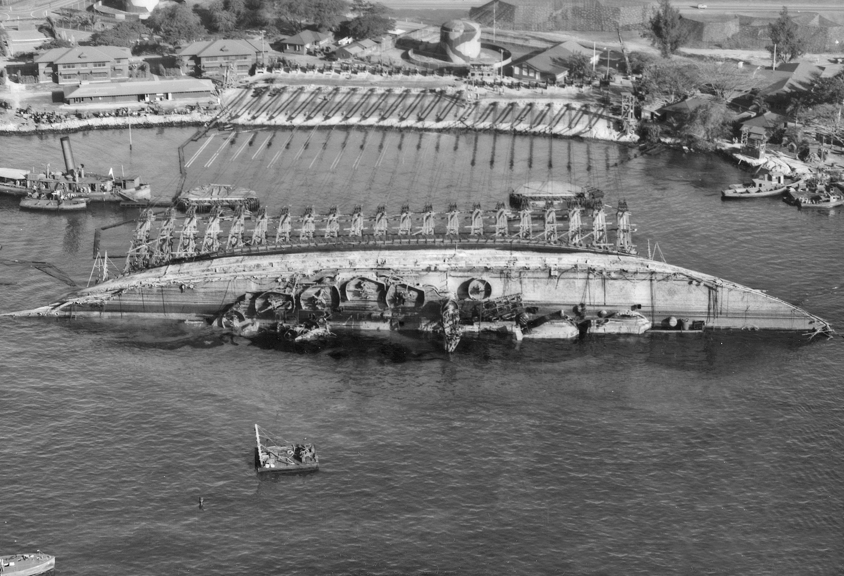 NASPH_%5E118506-_19_March_1943._USS_Oklahoma-_Salvage._Aerial_view_toward_shore_with_ship_in_90_degree_position._-_NARA_-_296975.jpg