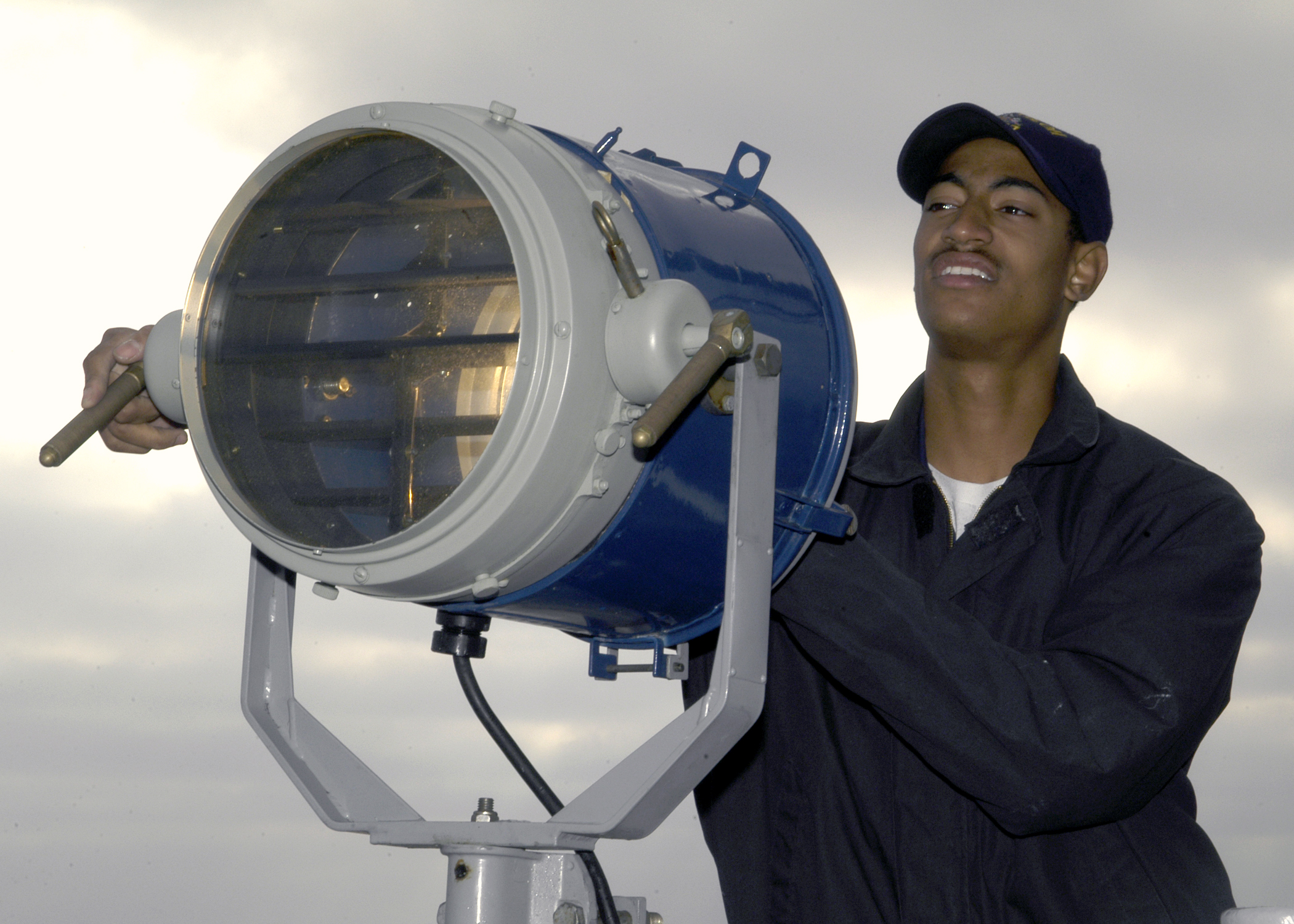 US_Navy_031015-N-9214D-014_Signalman_3rd_Class_Jeff_Allen_uses_a_signal_light_to_communicate_with_other_ships_in_the_vicinity_during_missile_firing_exercises_off_the_coast_of_Southern_California.jpg