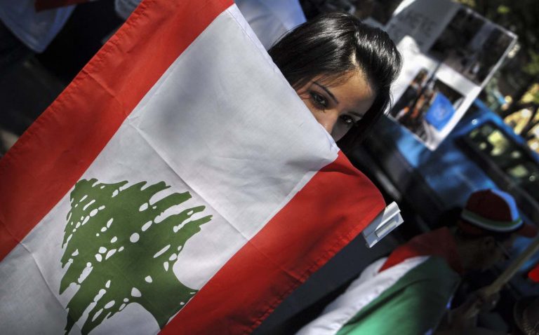 Woman-Holding-Lebanese-Flag-CC-Visible-Hand-via-Flickr-768x478.jpg