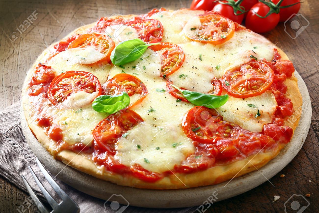 19271412-Italian-pizza-with-tomato-topped-with-melted-golden-cheese-herbs-and-basil-served-on-a-round-wooden--Stock-Photo.jpg
