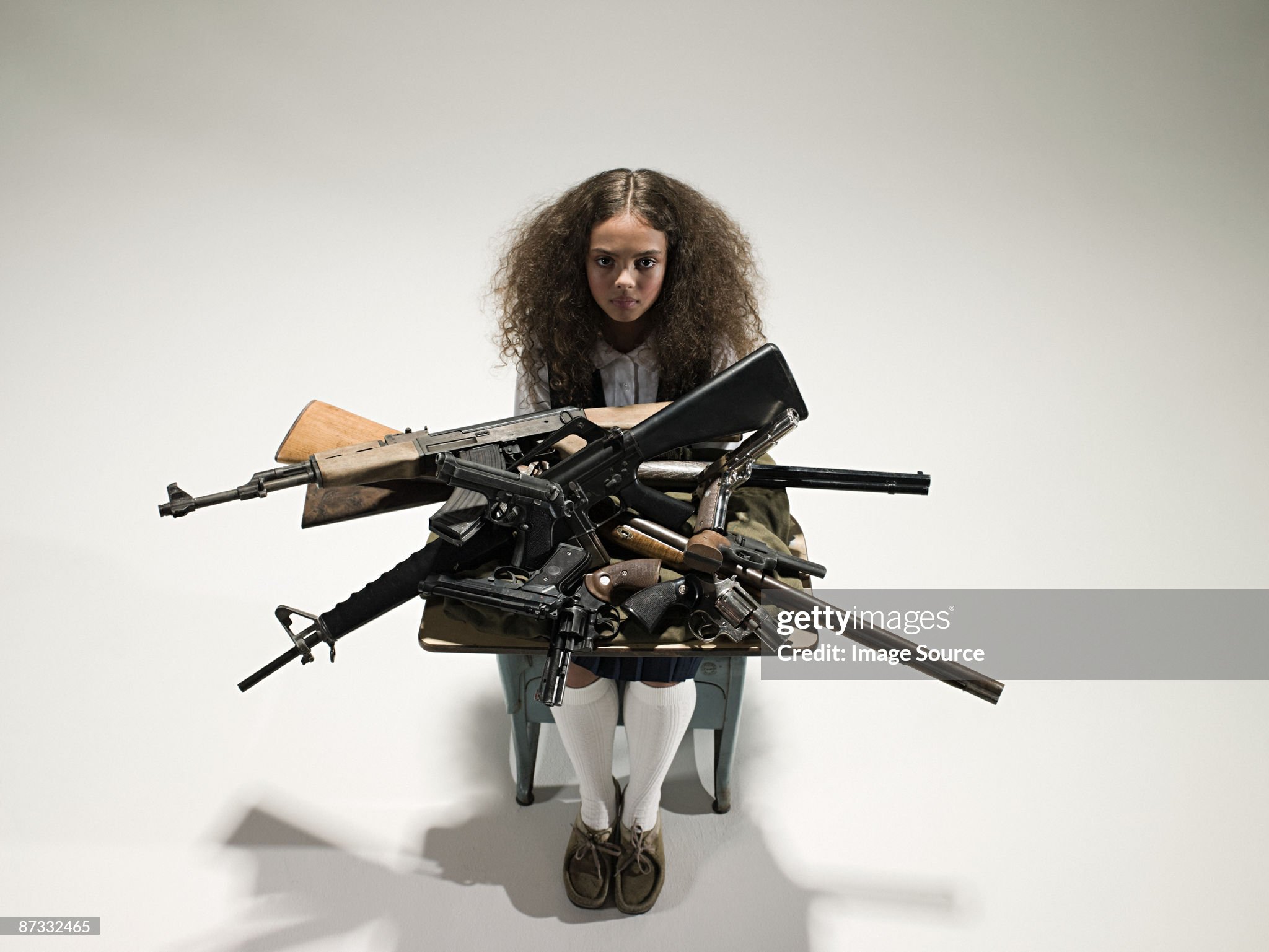 girl-with-guns-on-her-desk-picture-id87332465