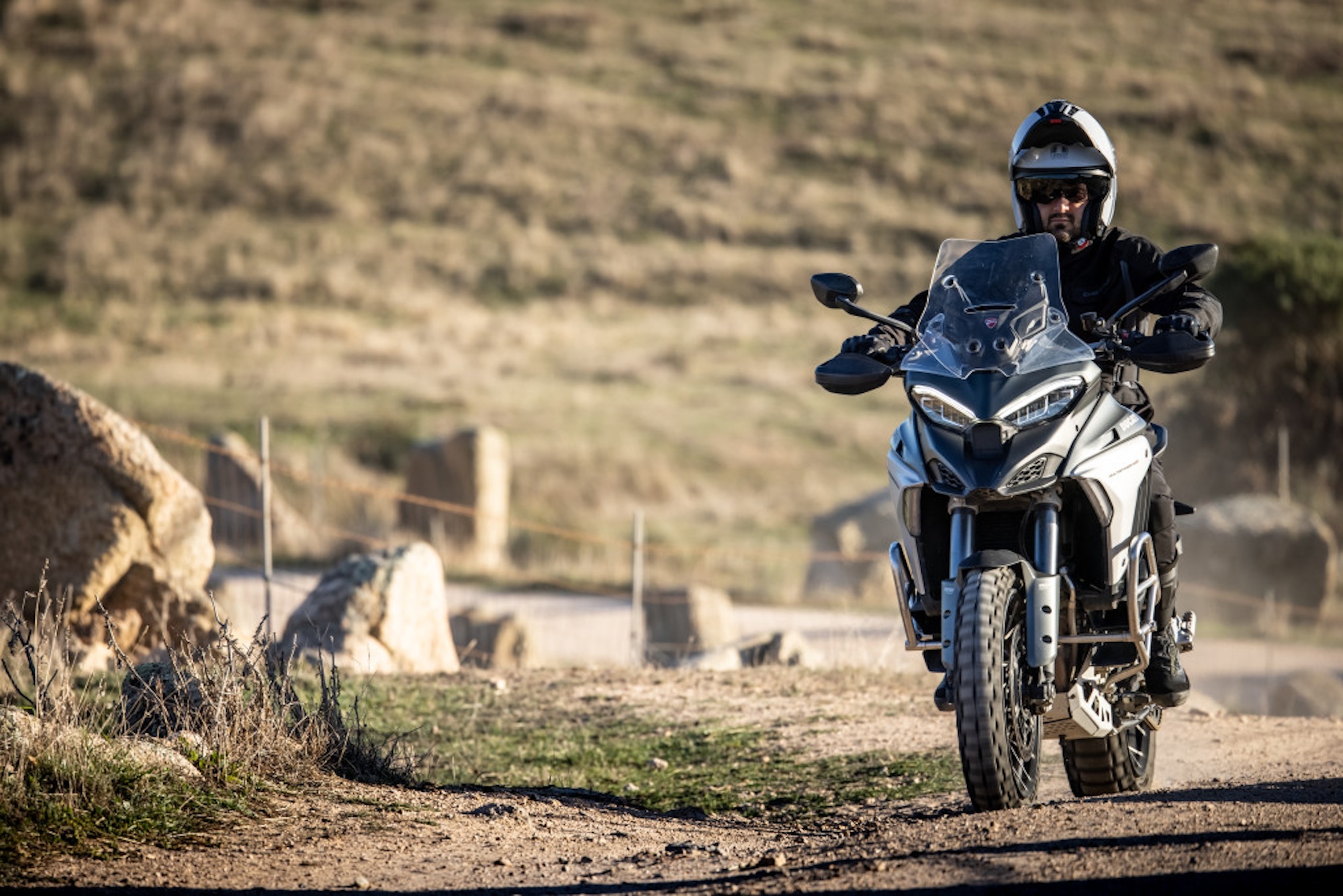 A motorcyclist wearing a helmet on a motorcycle.