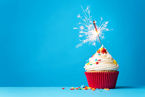 cupcake-with-sparkler-on-blue-picture-id467704570