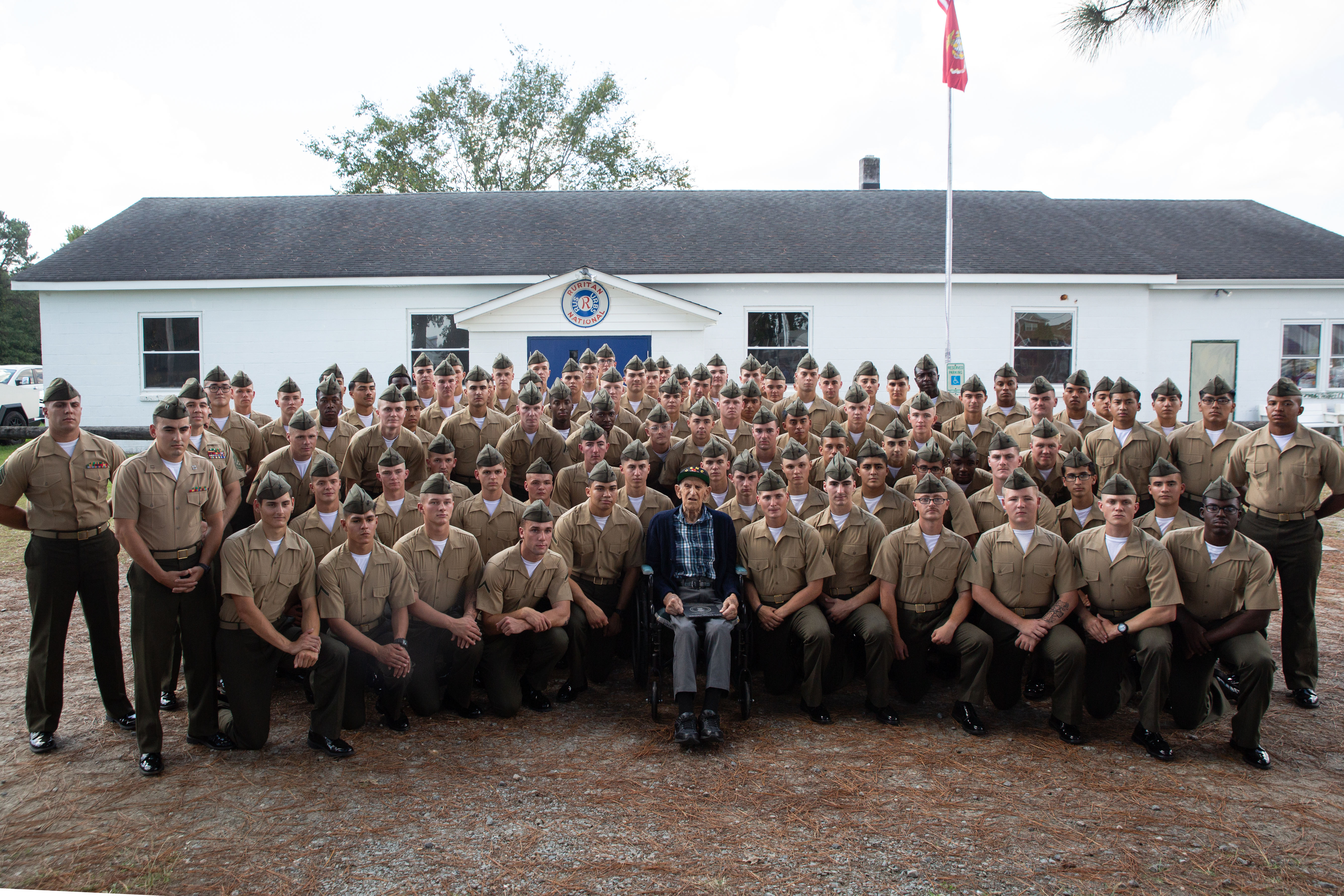 U.S. Marine Corps veteran, Cpl. Eddie Vincek, a WWII veteran and Battle of Iwo Jima survivor, poses for a group photo with Marines from Training Company , Marine Corps Security Forces Regiment during his 100th birthday celebration at the Ruritan Club, Chesapeake, Va., Sept. 29, 2024. Vincek served with ‘A’ Company, 1st Battalion, 28th Marine Regiment, 5th Marine Division in the Battle of Iwo Jima which was one of the last and most violent struggles of the WWII campaign in the Pacific. During the celebration, Vincek was joined by close family and friends and honored with a challenge coin and plaque. (U.S. Marine Corps photo taken by Lance Cpl. Catherine S. Verenzuela Mariano)