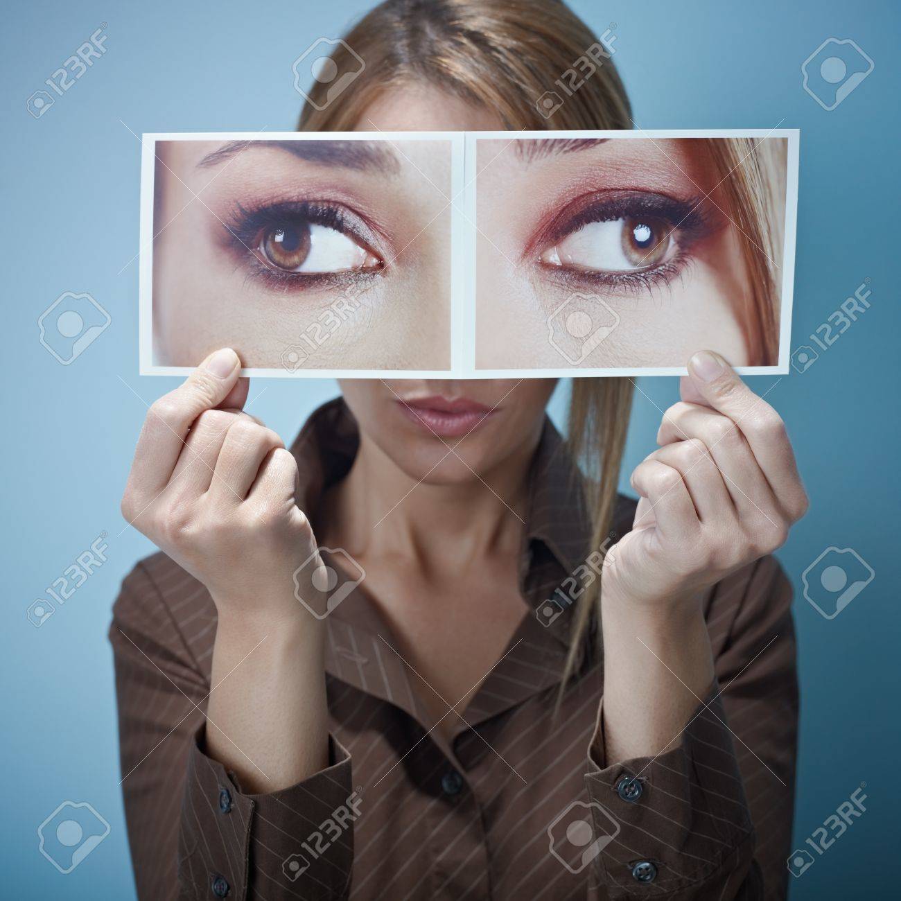 8269945-mid-adult-business-woman-holding-photo-of-her-eyes-looking-at-different-sides-on-blue-background-squ.jpg