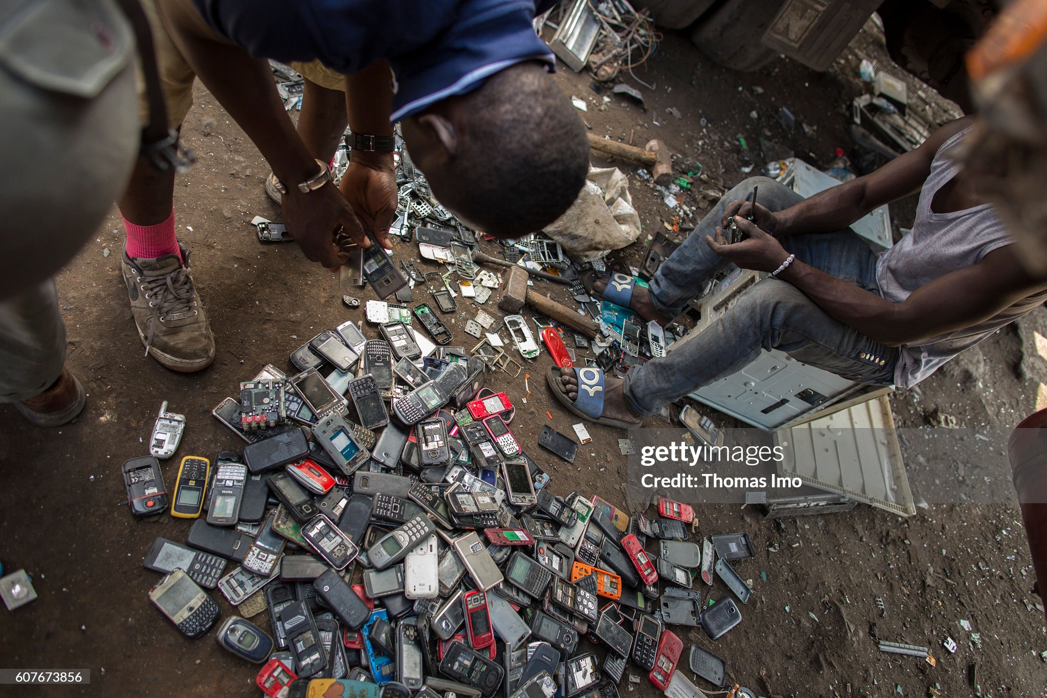 young-africans-disassemble-old-mobile-phones-on-the-largest-scrap-picture-id607673856