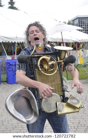 stock-photo-winnipeg-mb-june-street-performer-playing-one-man-band-instrument-is-entertaining-the-120722782.jpg