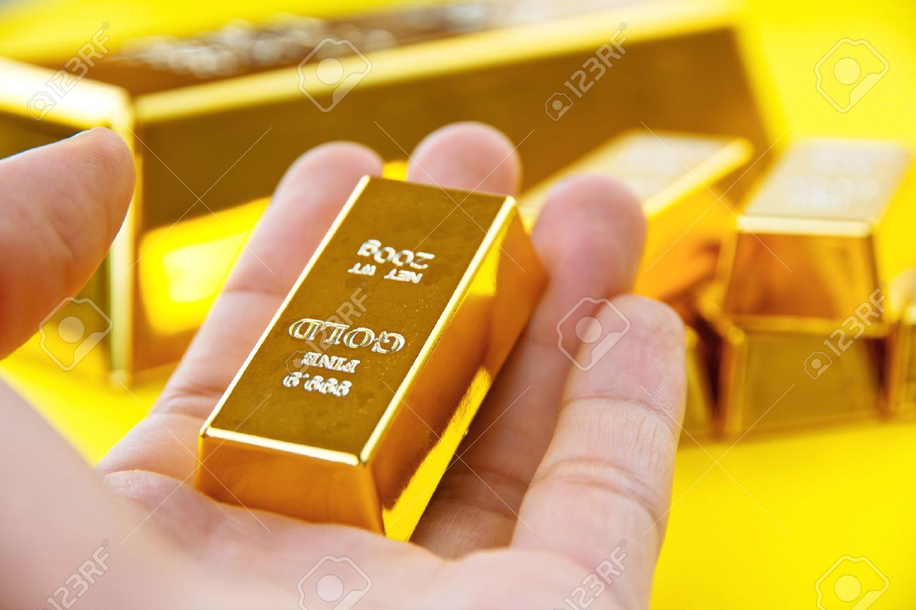12204419-Hand-hold-gold-bars-Stock-Photo-gold-bar-coins.jpg