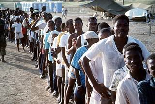 Haitian refugees stand in line at Camp McCalla, site of a humanitarian relief center for Haitians fleeing political and economic upheaval in their homeland