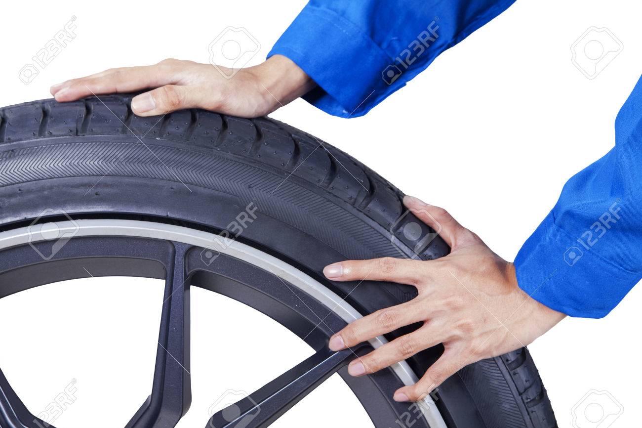 38147099-closeup-of-mechanic-hands-pushing-a-black-tire-in-studio-isolated-on-white-background.jpg