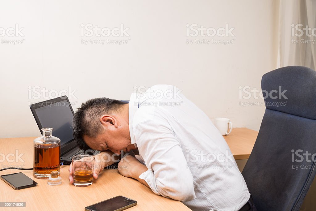 depressed-asian-business-manager-drunk-on-office-desk-picture-id505174936
