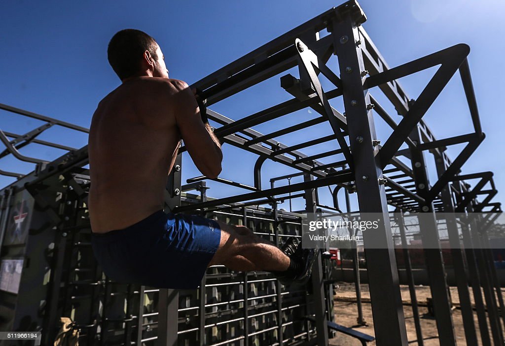 russian-soldier-doing-chinups-while-training-at-an-outdoor-gym-at-picture-id511966194