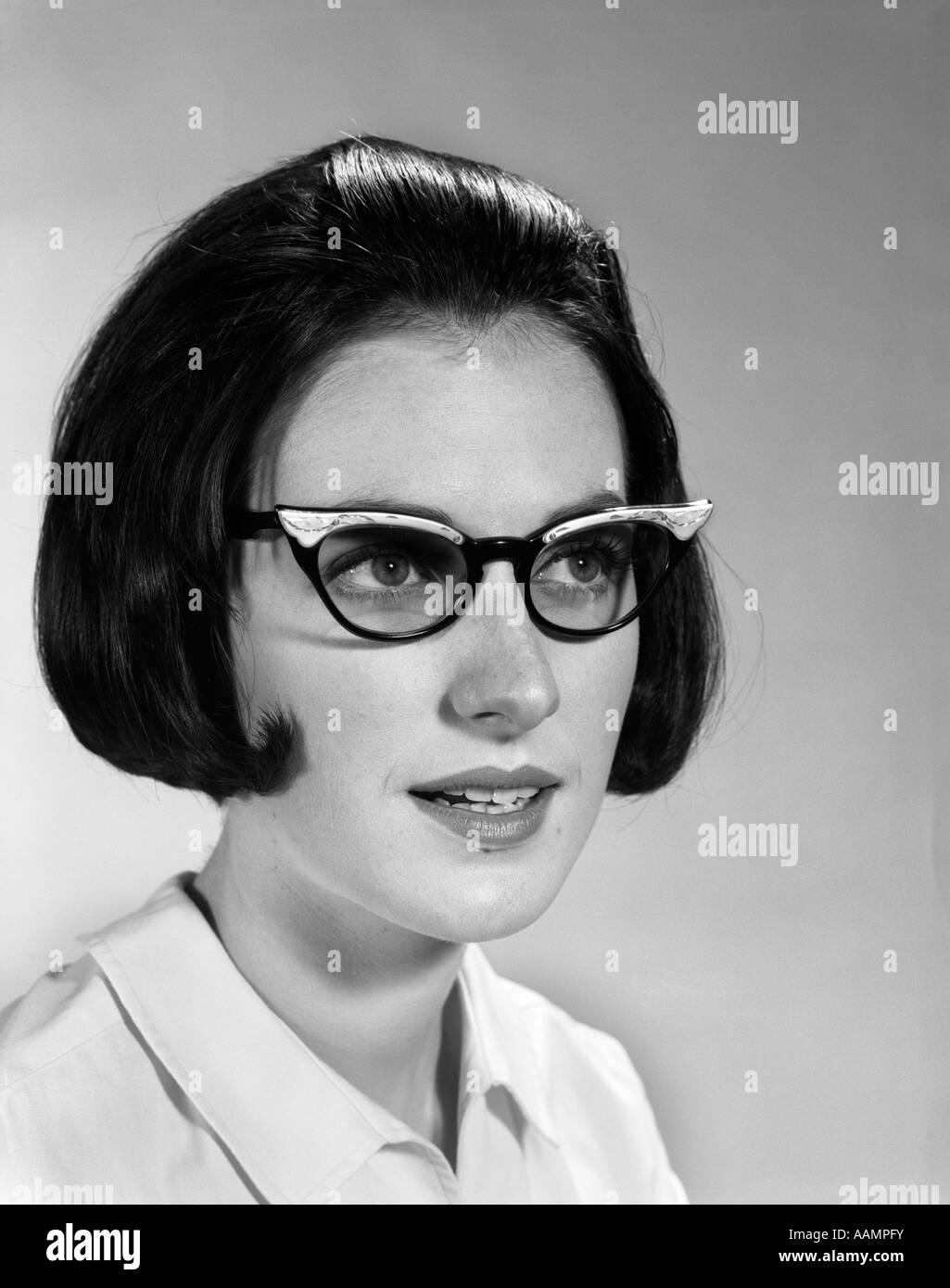 1960s-portrait-young-brunette-woman-wearing-fashion-frame-eyeglasses-AAMPFY.jpg