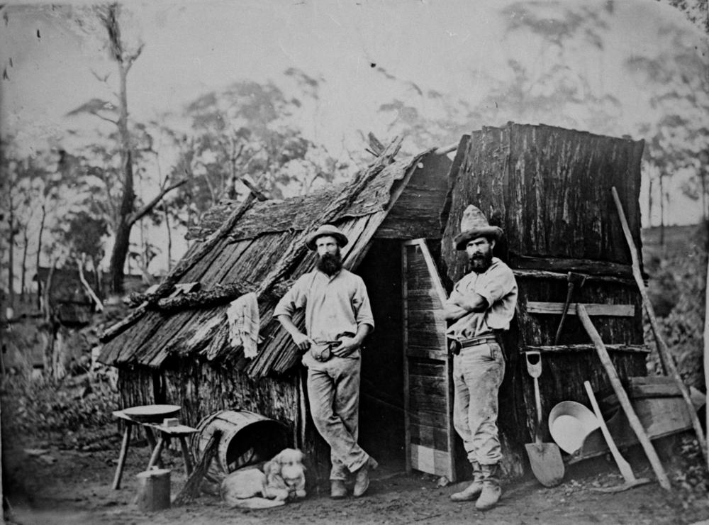 StateLibQld_1_102208_Gold_miners_outside_a_bark_hut,_Queensland,_ca._1870.jpg