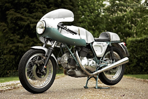 A 1974 Ducati 750SS motorcycle parked on a tree-lined driveway