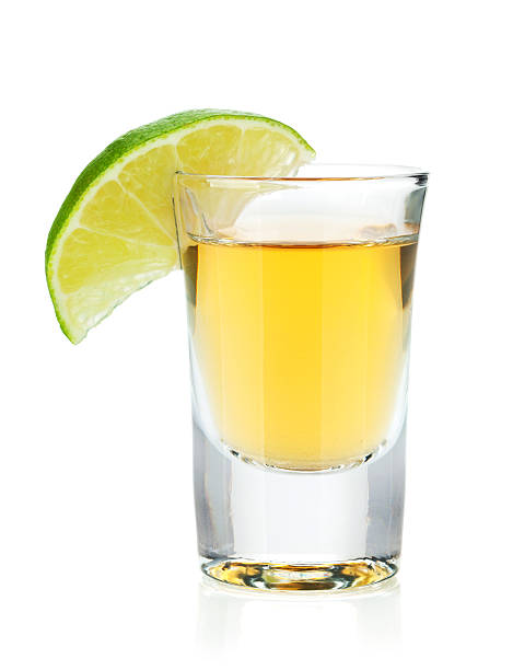 shot-of-gold-tequila-with-lime-slice-picture-id158769352