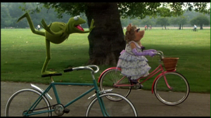 the_muppets_kermit_and_piggy_riding_bikes_in_the_great_muppet_caper.png