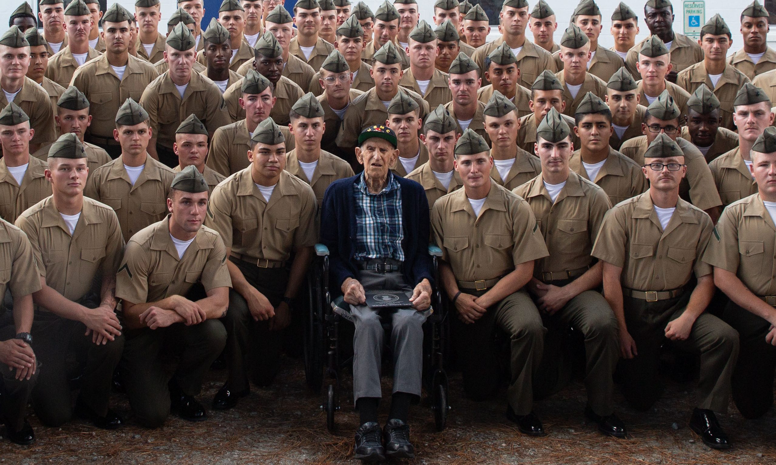 U.S. Marine Corps veteran, Cpl. Eddie Vincek, a WWII veteran and Battle of Iwo Jima survivor, poses for a group photo with Marines from Training Company , Marine Corps Security Forces Regiment during his 100th birthday celebration at the Ruritan Club, Chesapeake, Va., Sept. 29, 2024. Vincek served with ‘A’ Company, 1st Battalion, 28th Marine Regiment, 5th Marine Division in the Battle of Iwo Jima which was one of the last and most violent struggles of the WWII campaign in the Pacific. During the celebration, Vincek was joined by close family and friends and honored with a challenge coin and plaque. (U.S. Marine Corps photo taken by Lance Cpl. Catherine S. Verenzuela Mariano)