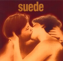 a hazy sepia photograph of two androgynous people kissing; the word “suede” is printed above in lower case