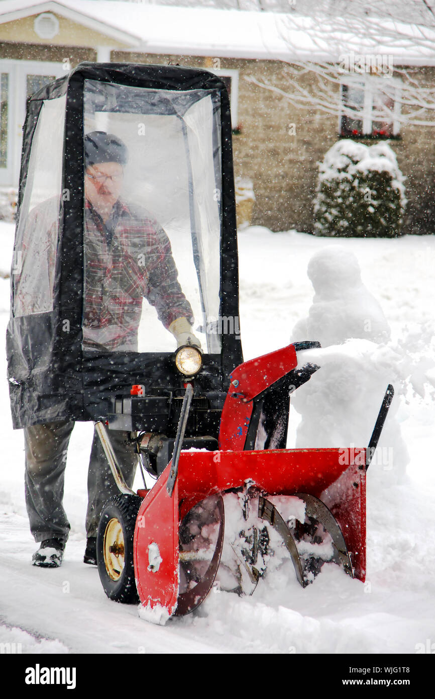 man-uisng-snowblower-in-his-home-entryway-during-a-winter-blizzard-WJG1T8.jpg