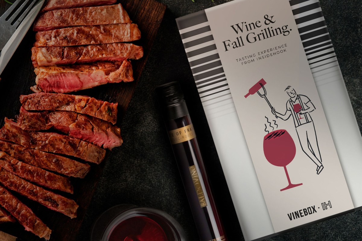 a grilled stea, vial of red wine, vinebox box and glass of red wine on a black background