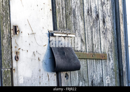padlock-under-rubber-flap-on-old-abandoned-barn-frjr22.jpg